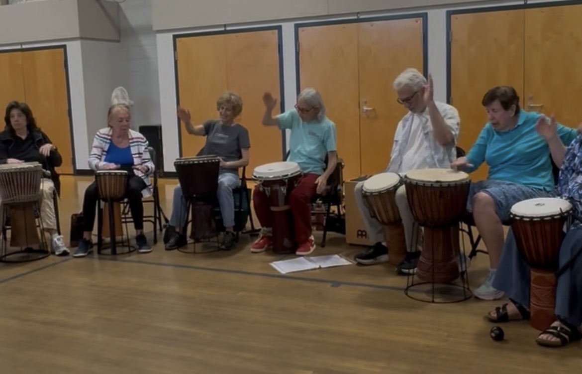 CMAP participants joining in a group drumming exercise